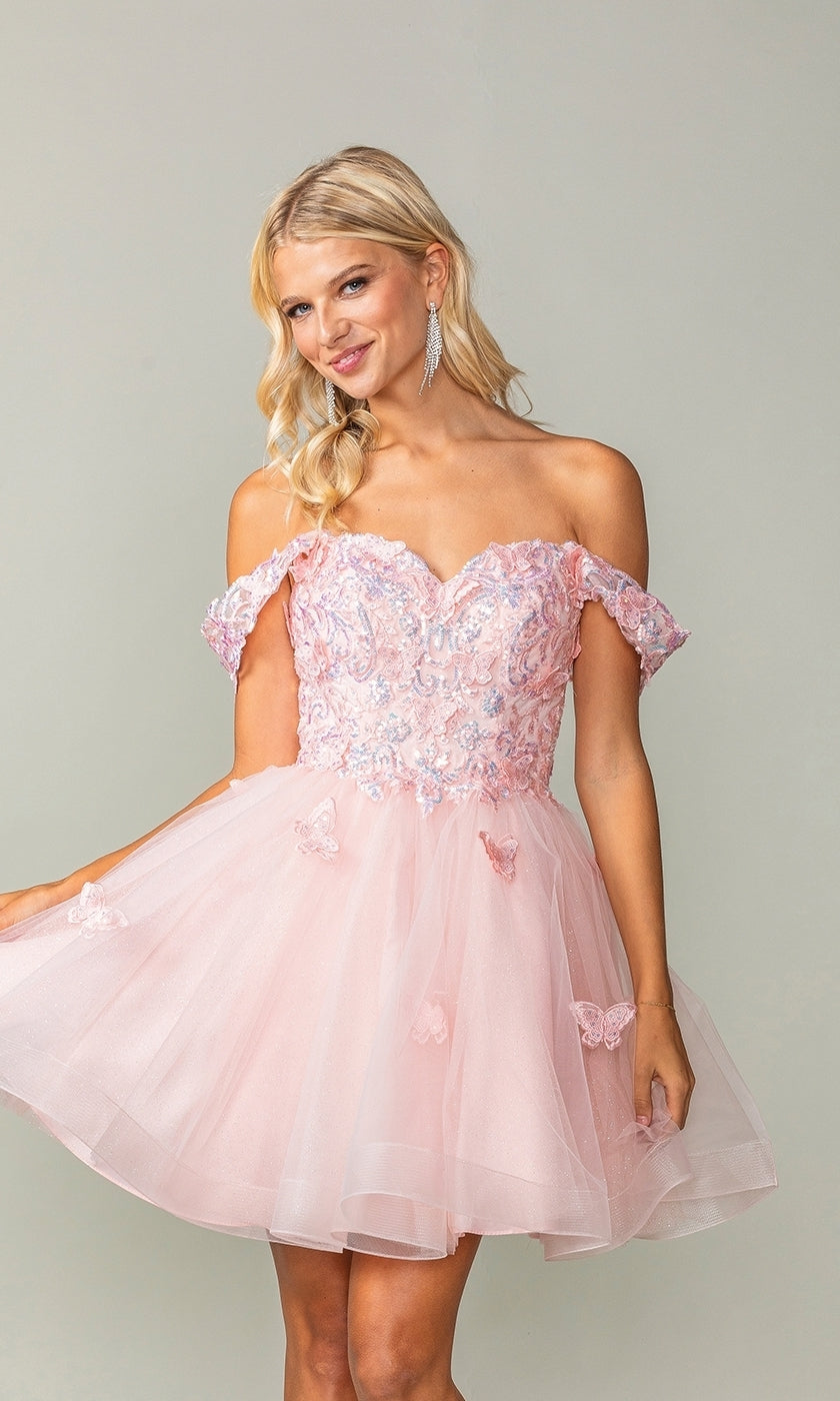 A woman models the Embroidered-Lace Short Babydoll Hoco Dress 3338—an off-shoulder, light pink dress featuring floral embroidery and a tulle skirt—standing against a plain background.