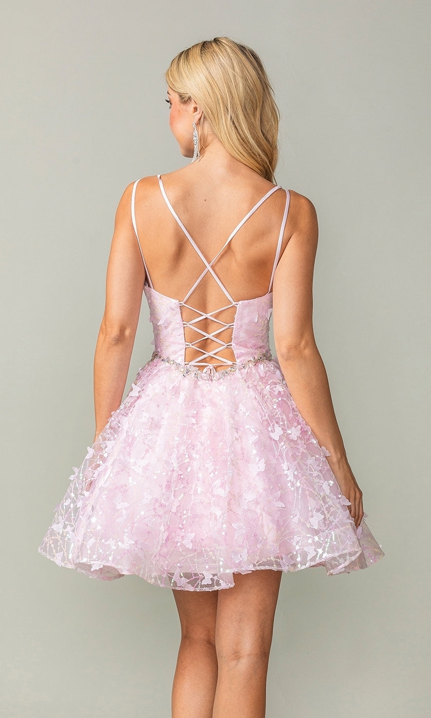 Woman in the Three-D Short Butterfly Homecoming Dress 3350—pink, above-the-knee with butterfly and floral patterns, spaghetti straps, corset-style bodice, and crisscross lace-up back—stands against a plain background.