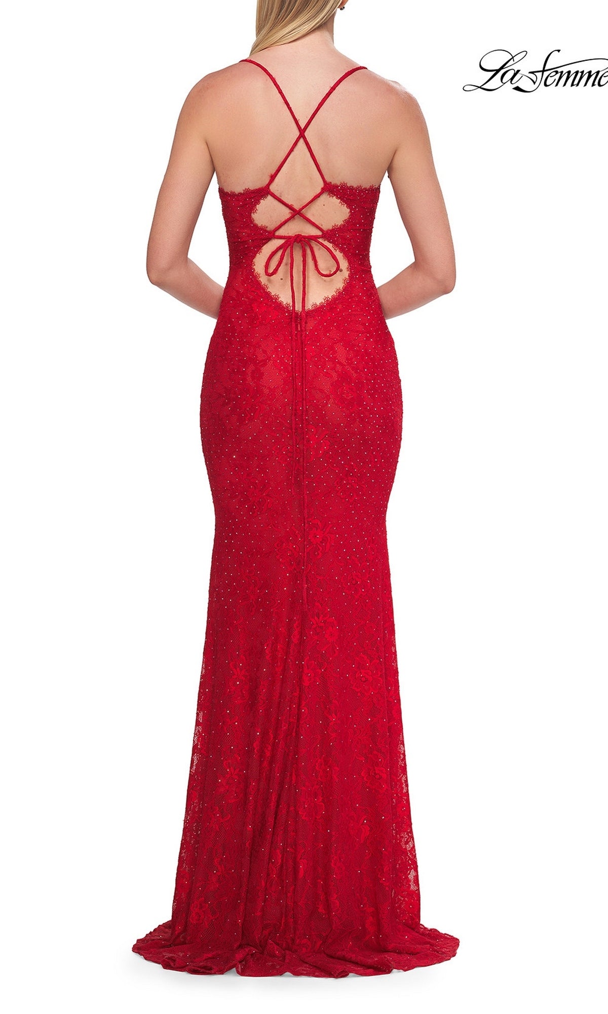 A woman wearing the La Femme 33514 long prom dress, featuring fitted red lace with crisscross straps, an open back with tie detail, a delicate scalloped V-neckline, and subtle rhinestone embellishments, photographed from behind.