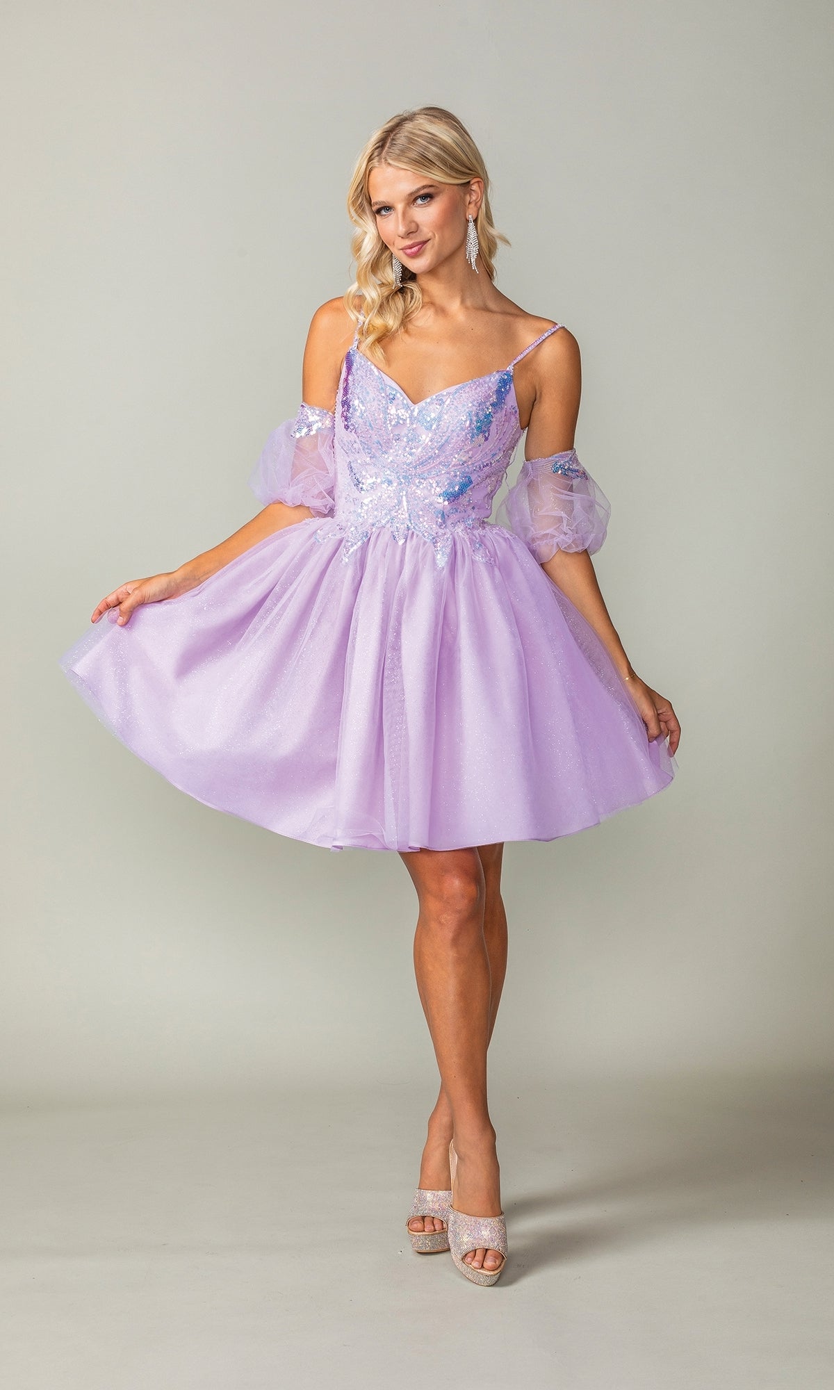 A woman models the Puff-Sleeve Short Purple Homecoming Dress 3362, featuring sparkly embellishments, spaghetti straps, and sheer puff sleeves—perfect for a charming off-the-shoulder semi-formal look.