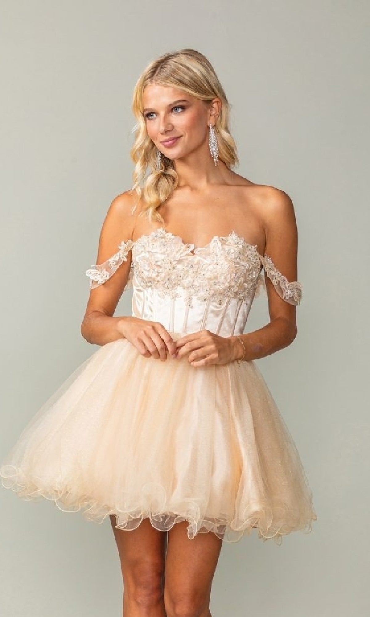 Woman wearing a strapless, a-line tulle dress with a plain background