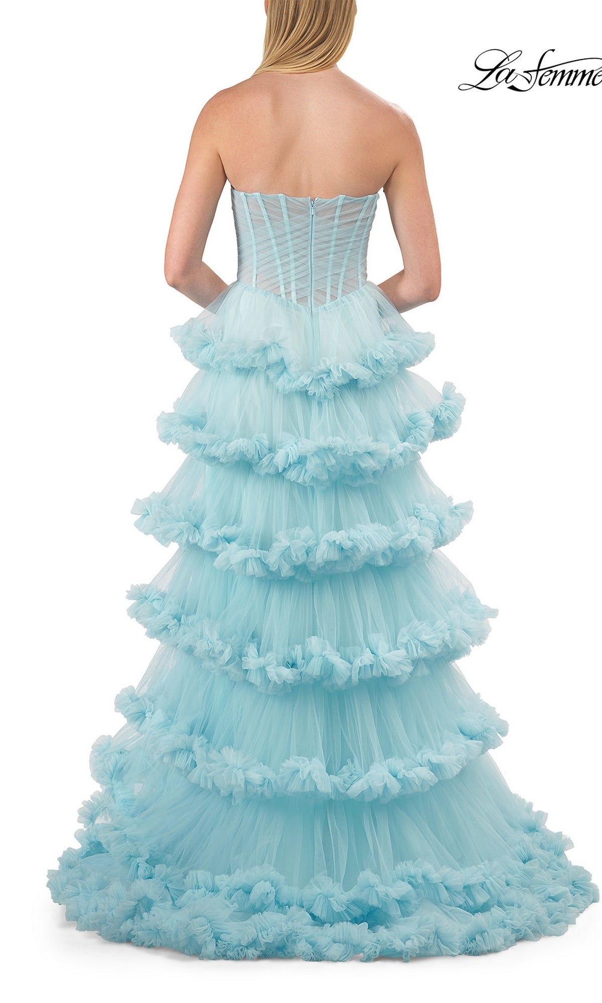 A woman stands with her back to the viewer, showcasing the Strapless Tiered Prom Ball Gown: La Femme 33717—a stunning strapless sweetheart dress made from layers of light blue tulle with dramatic, ruffled tiers. Set against a white background, the La Femme logo is displayed in the upper right corner, emphasizing this elegant and voluminous ball gown.