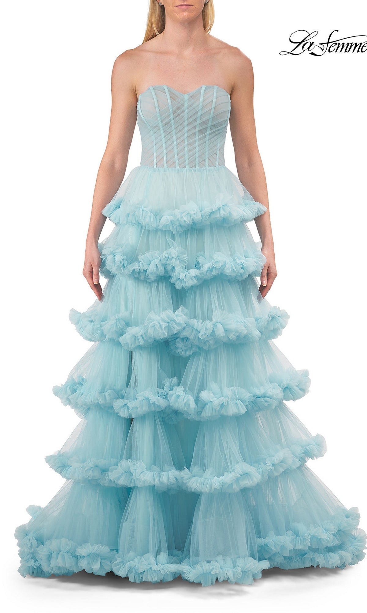 A woman wears the Strapless Tiered Prom Ball Gown: La Femme 33717, a light blue prom dress with a strapless sweetheart neckline, fitted bodice, and tiered full-length ball gown skirt.