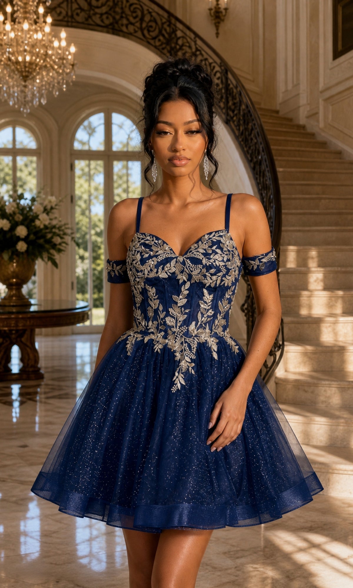 A woman stands indoors near a curved staircase and large windows, wearing the Dancing Queen 3432 short homecoming dress in navy, featuring tulle fabric, gold floral embroidery, and a boned corset.