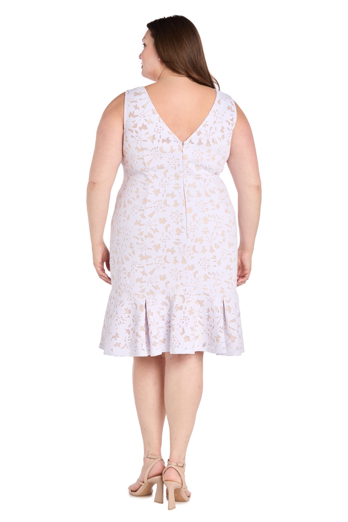 A woman models the R&M Richards 3506W Plus Knee Length Party Dress—a sleeveless, white floral cocktail dress with a ruffled hem—paired with nude heels, viewed from behind.