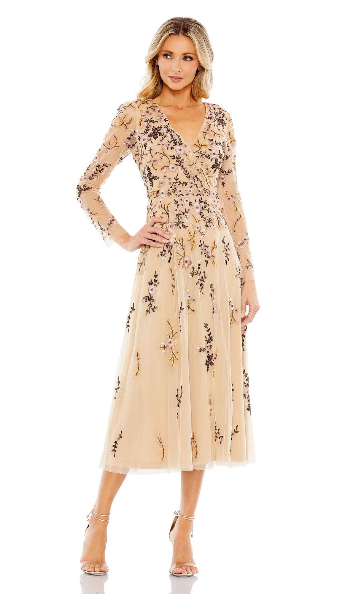 Woman in the Midi Floral Wedding Guest Dress by Mac Duggal, featuring long sleeves and floral embroidery, standing in heels against a white background.