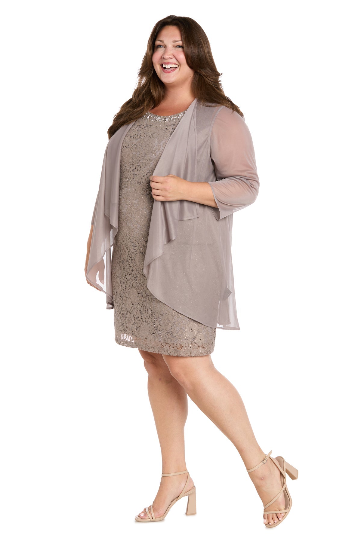 A woman wearing the Plus-Size Short Jacket Dress: R&M Richards 3594W in light taupe, styled with a sheer matching jacket and nude block-heeled sandals, smiles as she stands against a white background.