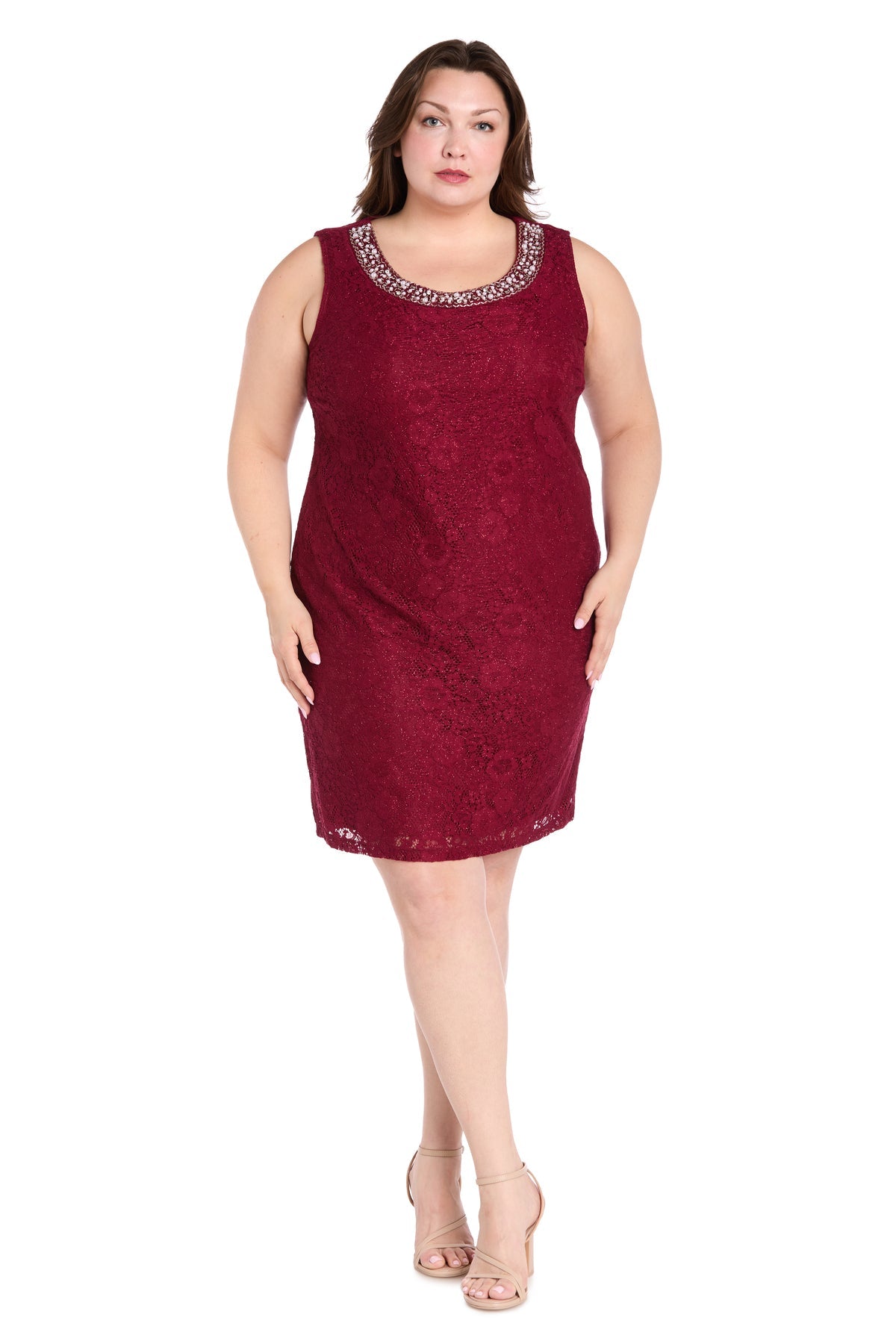 A woman faces forward against a white background, wearing the R&M Richards 3594W plus-size short jacket dress—a knee-length, sleeveless burgundy semi-formal outfit with embellished neckline—paired with nude heels.