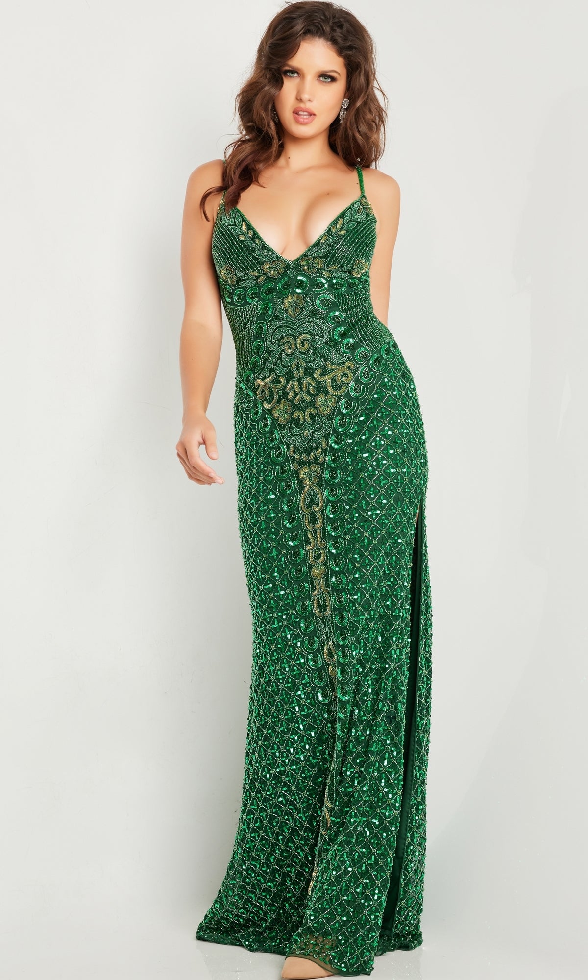 A woman models the Jovani 36643 Beaded-Mesh Long V-Neck Prom Dress, a sleeveless, floor-length green gown with beading, deep V-neckline, and side slit, standing against a plain white background.