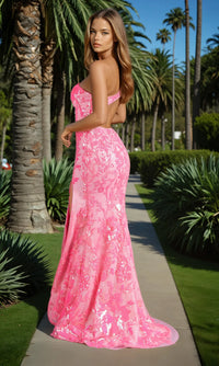 Woman in a pink strapless dress standing on a path with palm trees in the background