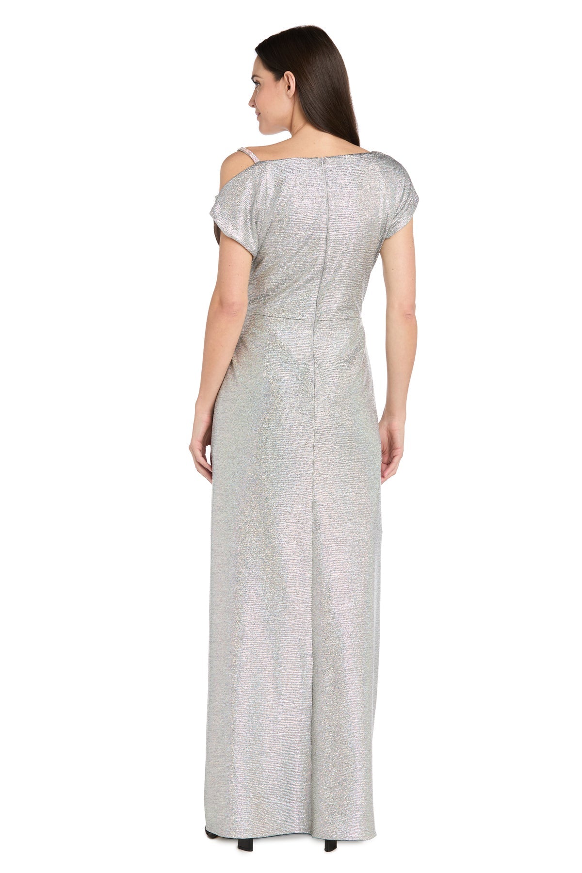 A woman faces away, wearing the R&M Richards 3758P Petite Silver Formal Dress—short-sleeved, floor-length with shimmering fabric and back seam detail—for a stunning formal evening look.