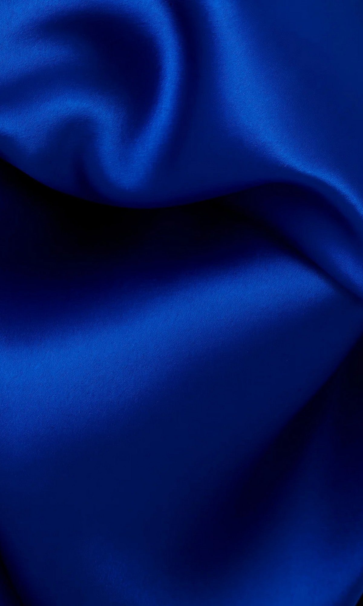 Close-up of smooth, royal blue satin fabric with soft folds and light reflections, reminiscent of the luxurious strapless Long Formal Dress: Jovani 38864.