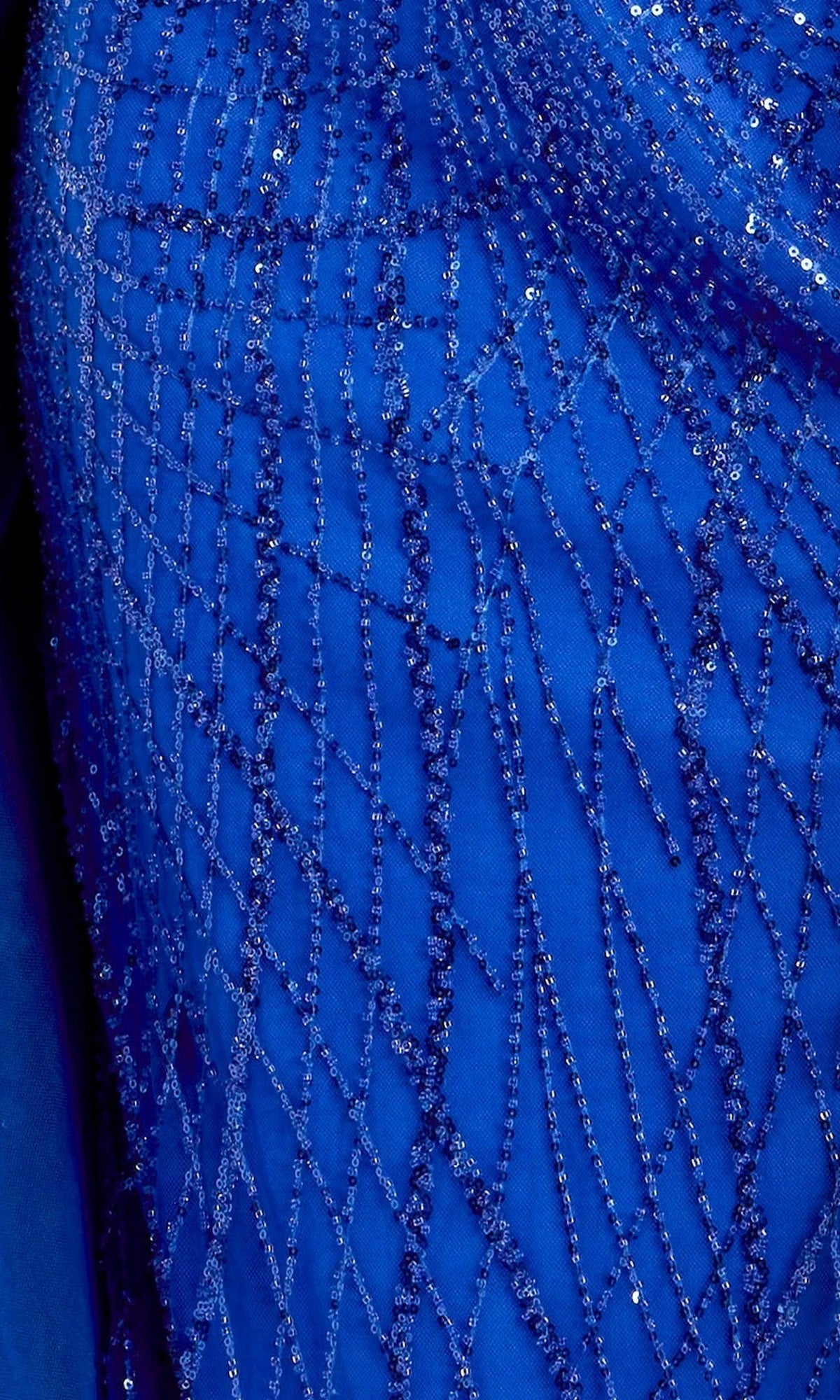 Close-up of royal blue fabric adorned with glittering diagonal and vertical sequin lines creating a striking geometric pattern, perfect for the Long Formal Dress: Jovani 39029 or any elegant sequin formal gown.