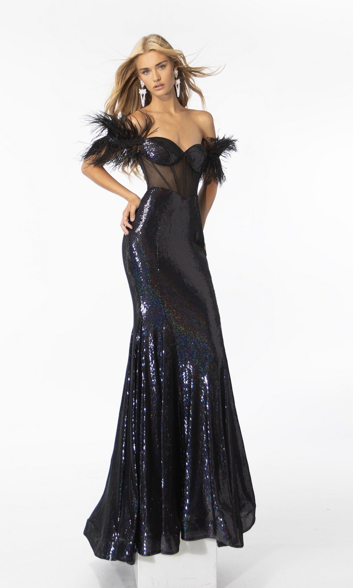 A woman models the Long Prom Dress 39205 by Ava Presley—a fitted, off-the-shoulder sequin mermaid gown with feathered sleeve accents, sheer paneling, and a flared hem—posing against a plain white backdrop.