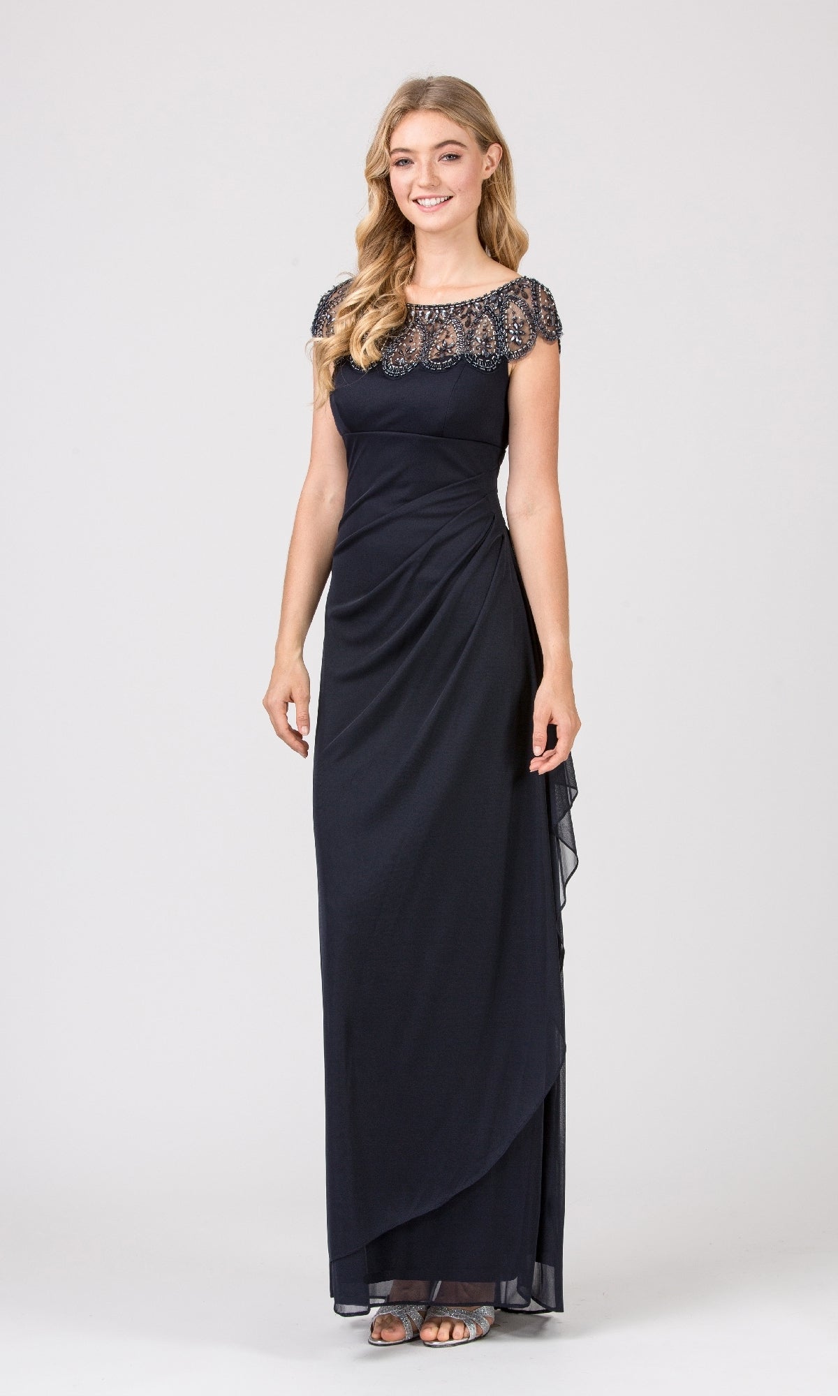 Woman standing and smiling in the Cap-Sleeve Long Formal Dress: Eureka 3927—a floor-length navy blue gown with lace bodice and cap sleeves, paired with silver sandals, her hair in loose waves.