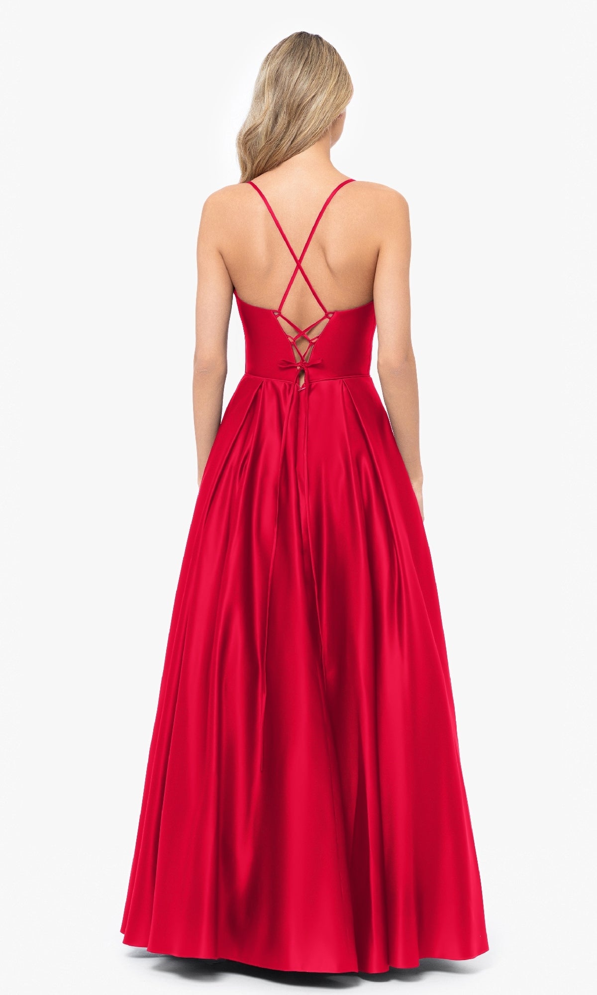 Woman wearing the Blondie Nites 3946BN long A-line prom dress in red satin, featuring a sleeveless design, corset-style waist, lace-up back, and crisscross straps, posing against a white background.