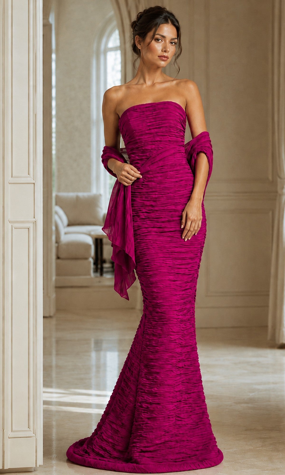 A woman wearing the Jovani 40045 long formal dress in fuchsia with a matching shawl, standing indoors in a spacious, elegant room.