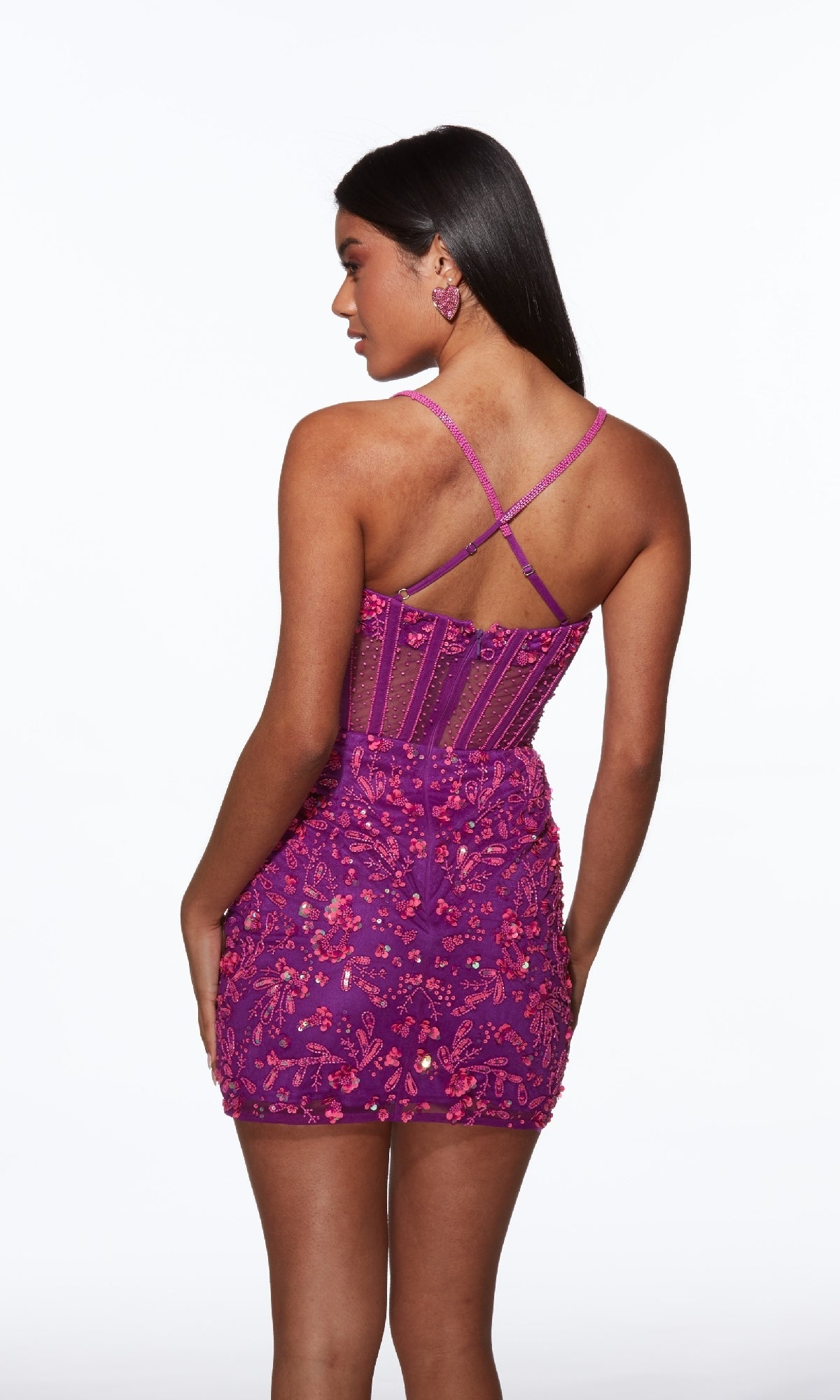 A woman in the Alyce 40093 short homecoming dress—purple sequin mini with crisscross back straps—stands facing away from the camera against a white background.