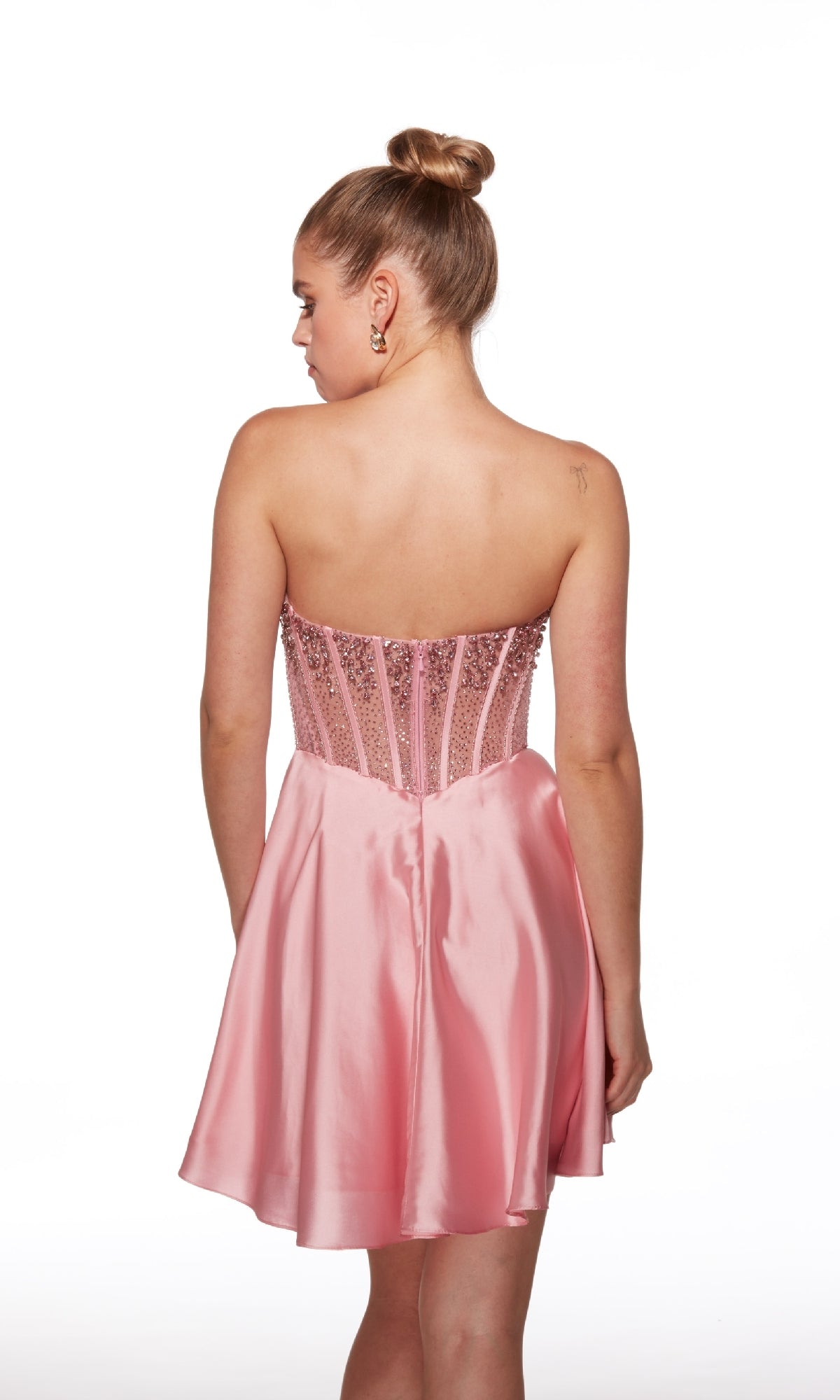 A woman faces away, wearing the Strapless Short Corset Hoco Dress Alyce 40101, featuring a fitted bead-embellished corset bodice and a satin skirt.