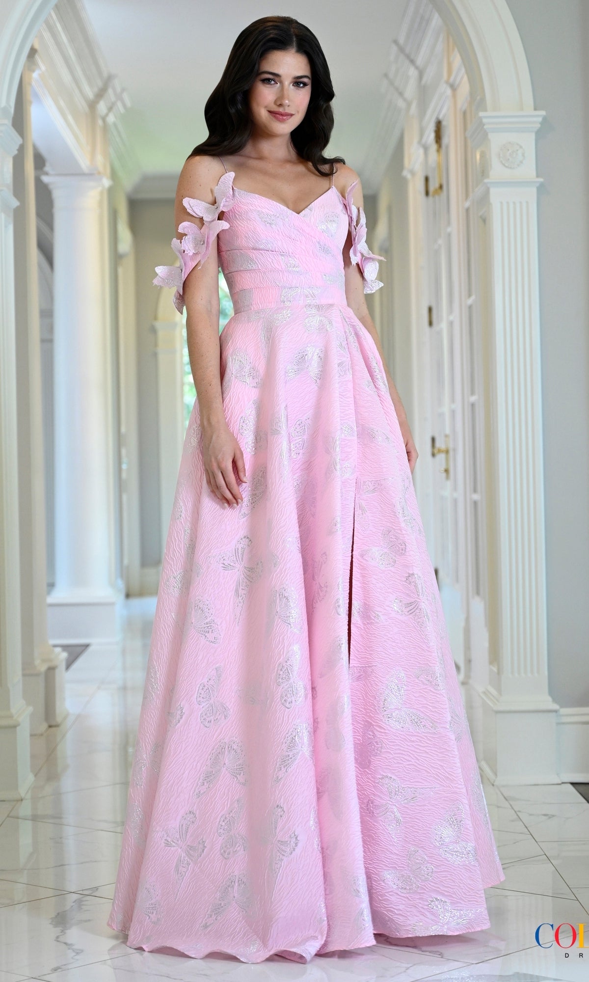 A floor-length pink V-neck Long Prom Dress: Colors Dress 4010 featuring off-the-shoulder accents, a butterfly motif, and a silver butterfly pattern on the skirt.