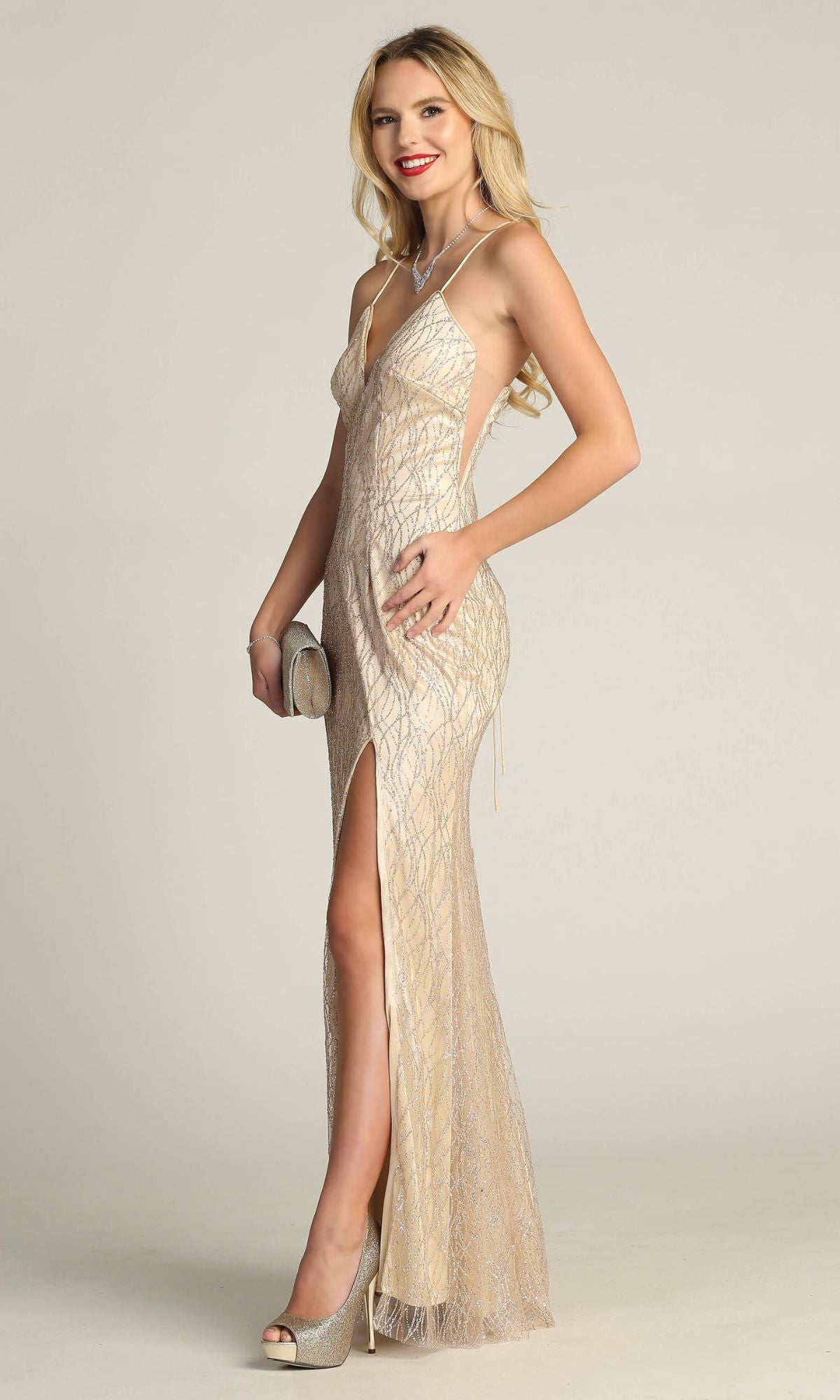 Woman in profile, smiling, wears the Corset-Back Glitter-Print Long Prom Dress 4023—a beige gown with a high slit—holding a clutch against a plain background.