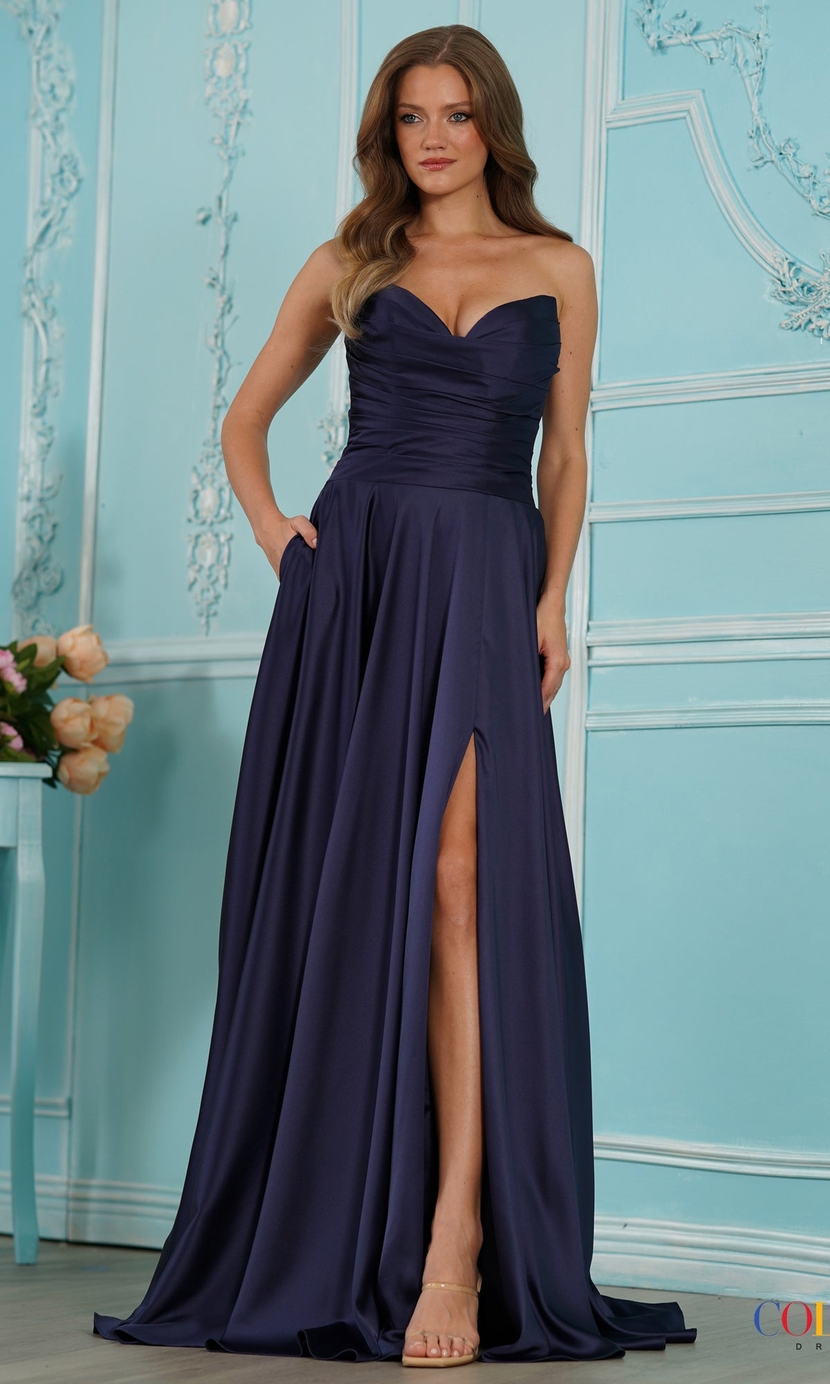 A navy Long Prom Dress: Colors Dress 4026, featuring a strapless floor-length draped design with a fitted bodice, pockets, and a high leg slit.