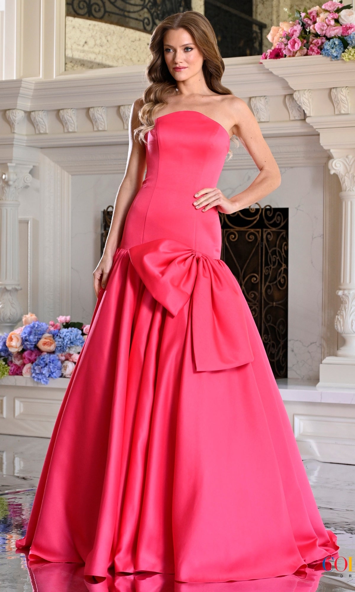 Hot pink, strapless, floor-length satin Colors Dress 4058 prom dress featuring an oversized bow at the waist.