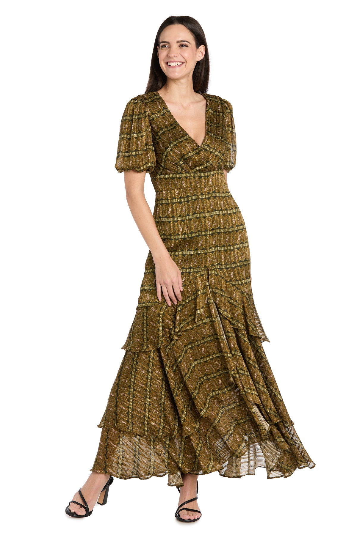 Woman wearing the Long Plaid Wedding Guest Dress: R&M Richards 4157, featuring an olive green hue, short sleeves, V-neck, tiered skirt, and black strappy heels, standing and smiling.