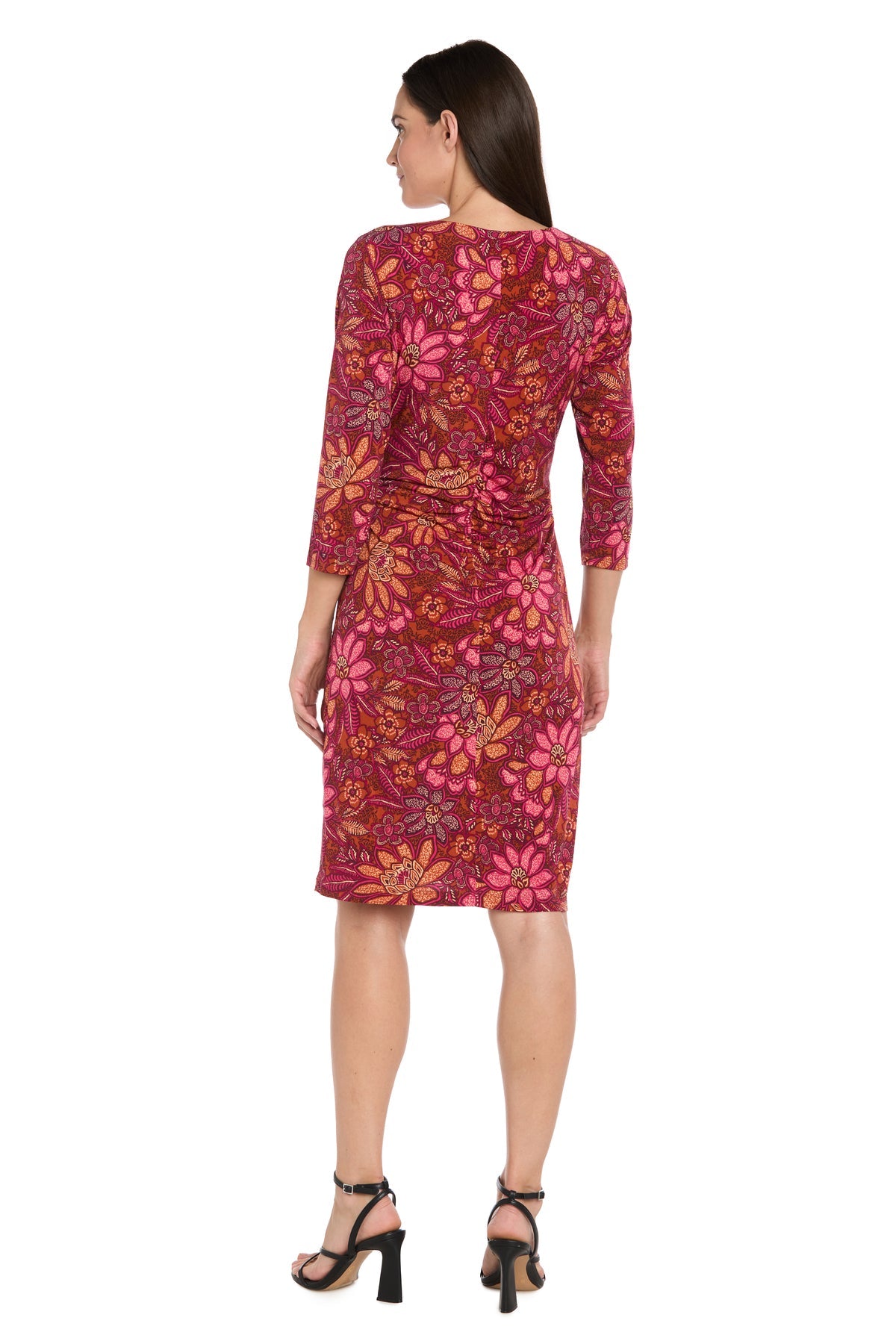 A woman stands facing away, wearing the R&M Richards 4171 red knee-length party dress with long sleeves and black heeled sandals.