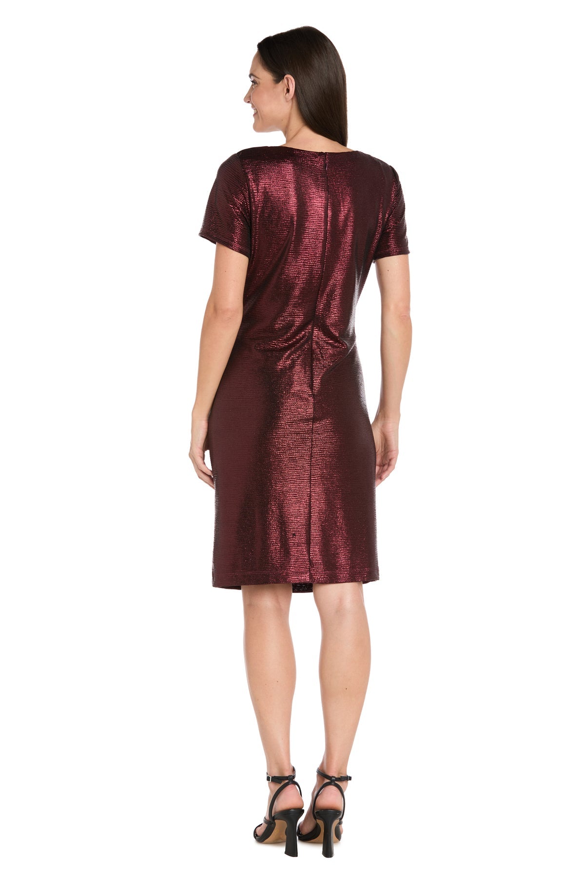 A woman stands with her back to the camera, wearing the R&M Richards 4177 Short Metallic Cocktail Dress and black heeled sandals against a white background.