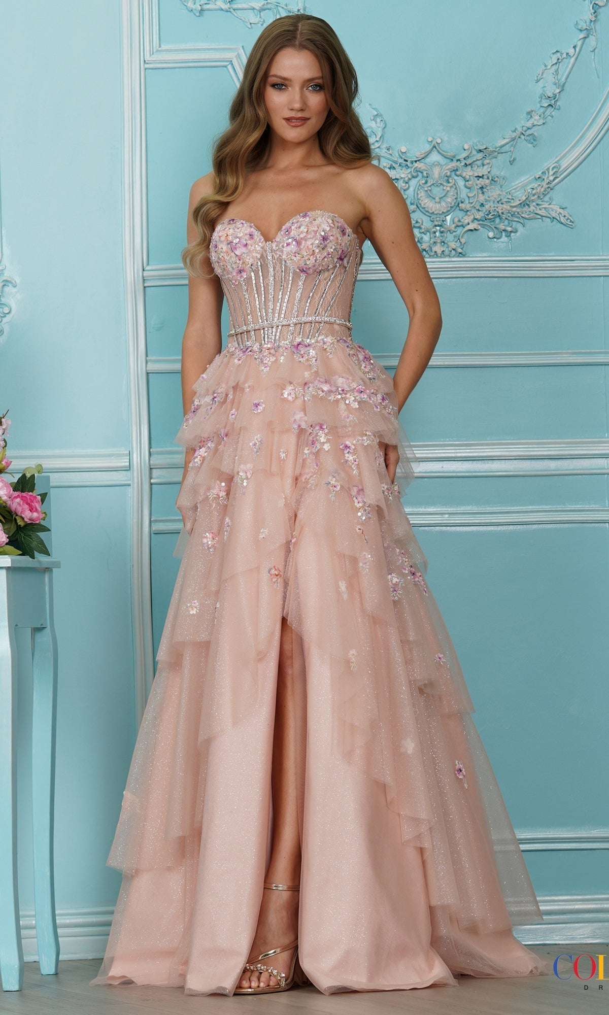Colors Dress 4209 long prom dress in blush, featuring a strapless beaded corset bodice, 3D flower embroidery, and a tiered skirt with a high front slit.