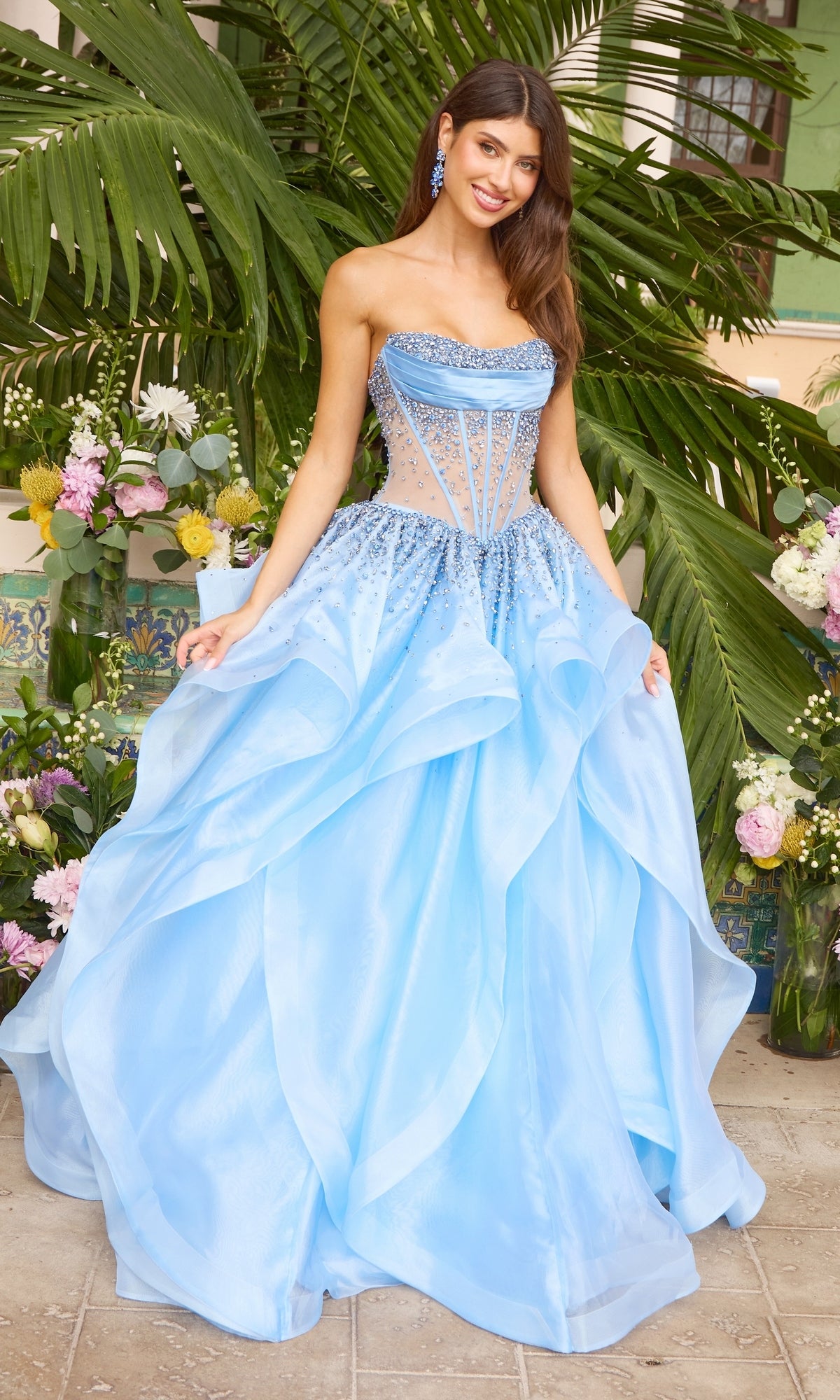 The Ava Presley 42482 long prom dress is a periwinkle ball gown featuring a strapless, corseted bodice and a layered, ruffled skirt.