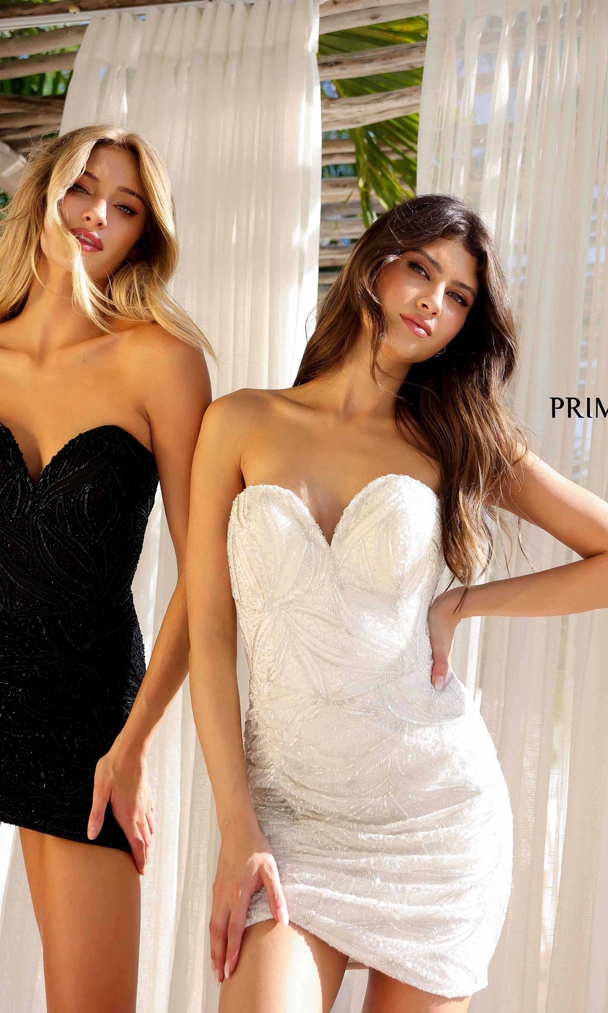 Two women pose in the Strapless Beaded Mini Hoco Dress: Primavera 4259, featuring a sweetheart neckline—one in black, one in white—before sheer curtains with sunlight streaming in, perfect for a chic party look.