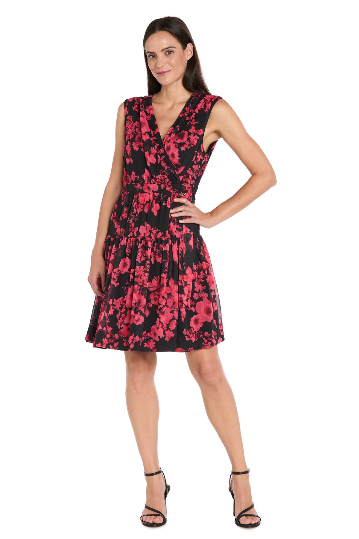 Woman wearing the Red Print Wedding Guest Dress: R&M Richards 4299—a sleeveless, knee-length black cocktail dress with a red floral pattern and black high-heeled sandals, posing confidently—ideal for chic wedding guest style.