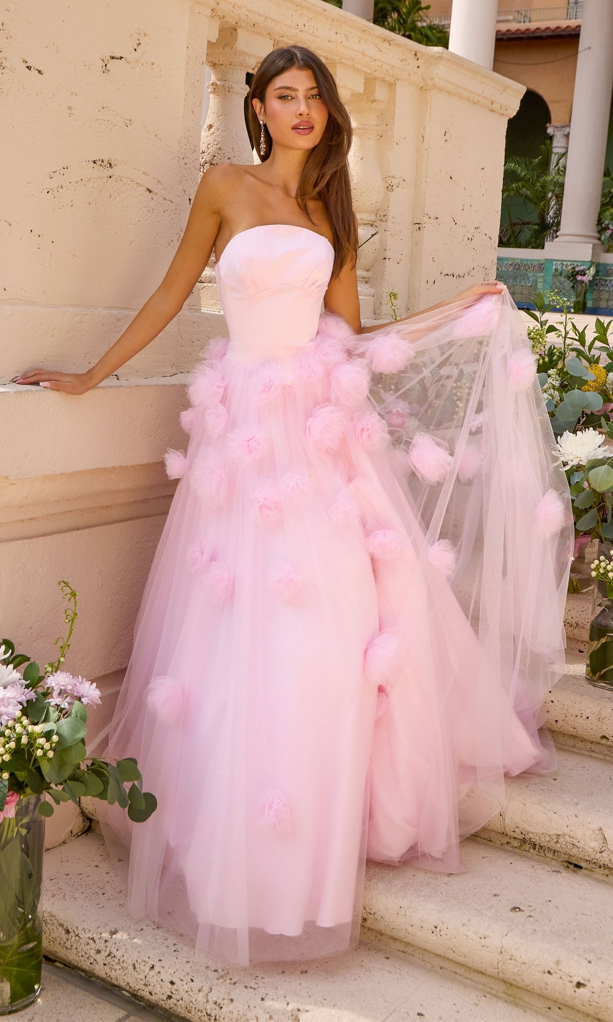 Ava Presley 43019 long prom dress featuring a strapless light pink ball gown with a fitted bodice and a full tulle skirt adorned with soft pom-poms.