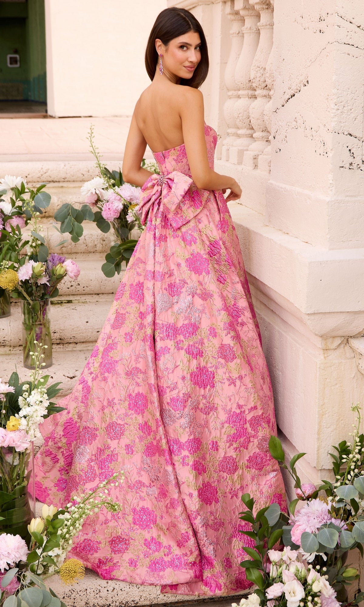 Ava Presley 43082 strapless pink floor-length prom ball gown with a floral pattern and a large bow at the back.
