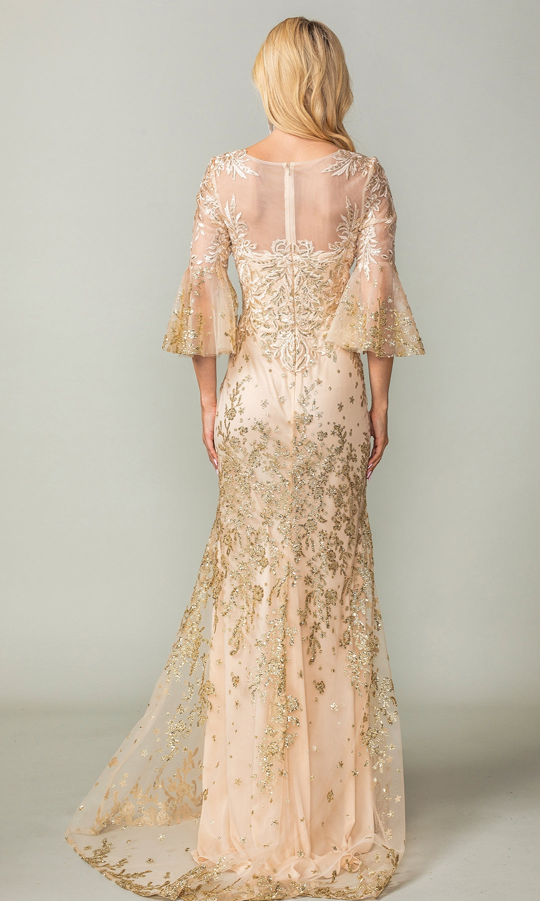 A woman with blonde hair models the Bell-Sleeve Long Prom Dress Dancing Queen 4361—light beige with gold embroidery and sheer bell sleeves—standing with her back to the camera against a plain background.