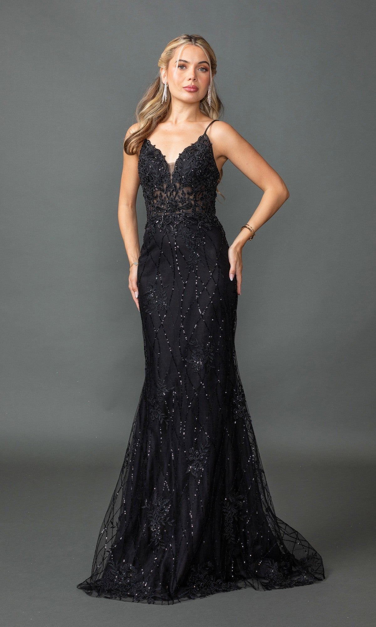 A woman poses against a gray backdrop in the Sequin-Print Long Prom Dress: Dancing Queen 4371, a sleeveless, floor-length black gown with a lace-up open back, fitted bodice, and sequin details.