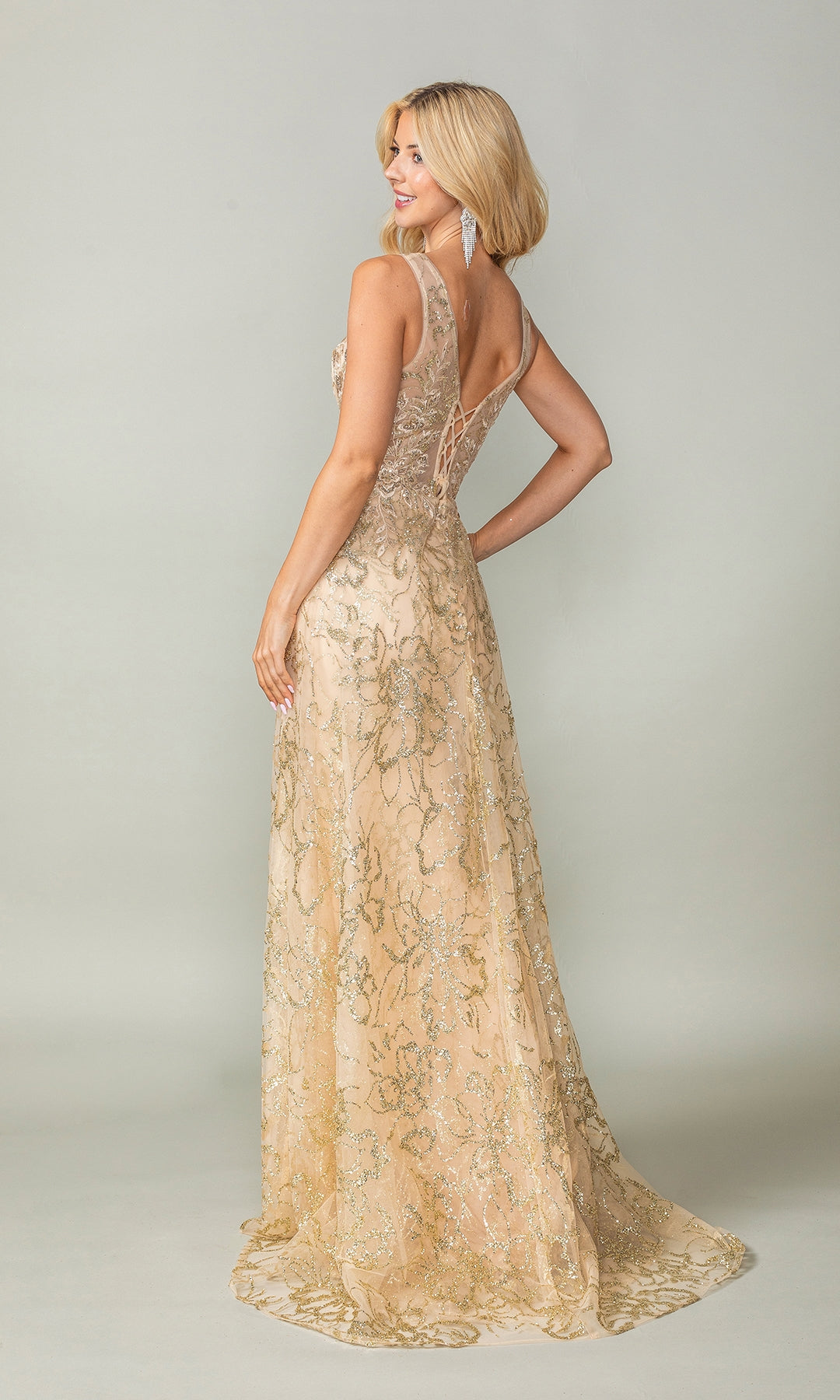 A woman models the Glitter-Print Lace-Up Long Prom Dress 4379—a sleeveless, floor-length gold lace gown with a fitted bodice and V-back—against a plain light background.