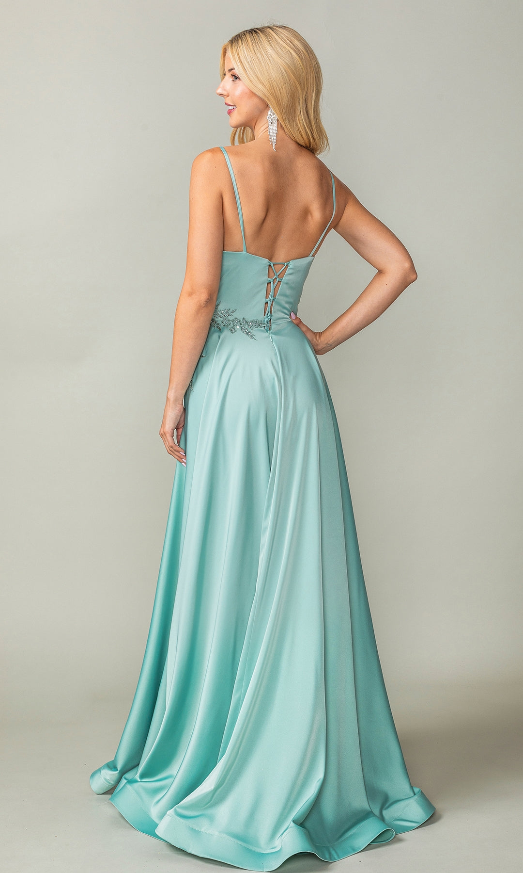 A woman in the Lace-Up-Back Long A-Line Prom Dress 4391, featuring light blue satin, thin straps, and a lace-up back, stands facing away while looking over her shoulder.