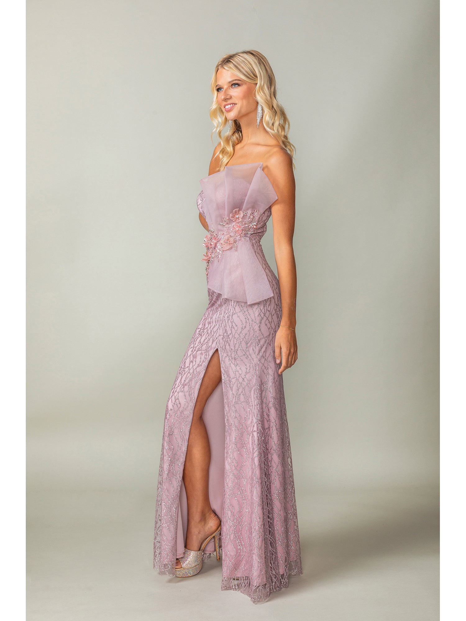 A woman models the Side-Bow Strapless Long Glitter Prom Dress 4394, a strapless evening gown with a high slit and shimmering details, against a plain background.