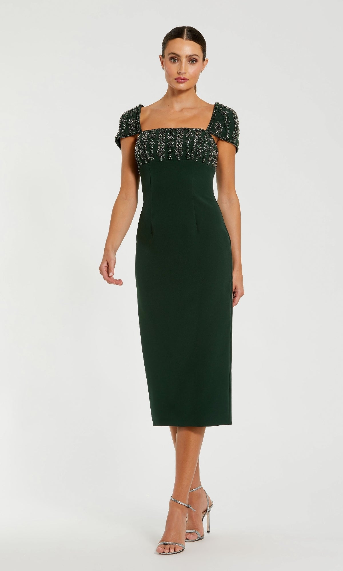 Woman wearing a green dress with beaded top on a white background