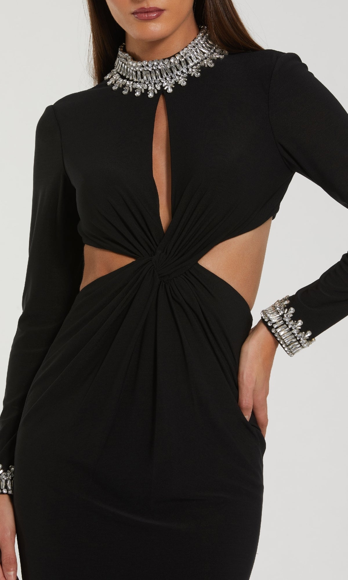 Woman wearing the Mac Duggal 44155 long formal dress, featuring long sleeves, jeweled neckline and cuffs, keyhole chest cutout, ruched twist at waist, and side cutouts.