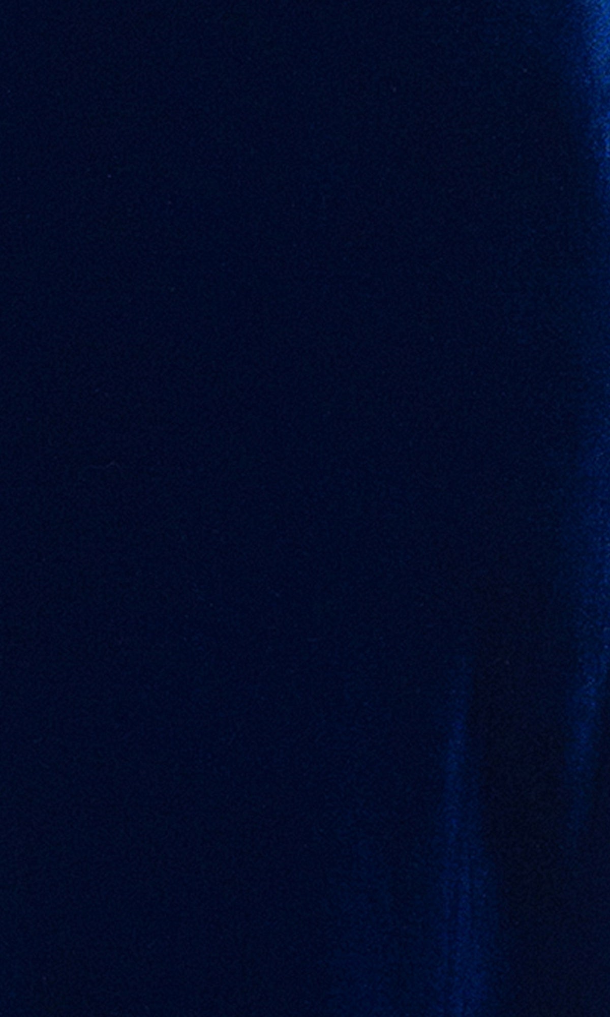 A close-up of the sleek, dark blue fabric from the Blondie Nites 4494BN Prom Dress, showing its smooth texture and subtle sheen with gentle creases reminiscent of elegant evening wear.