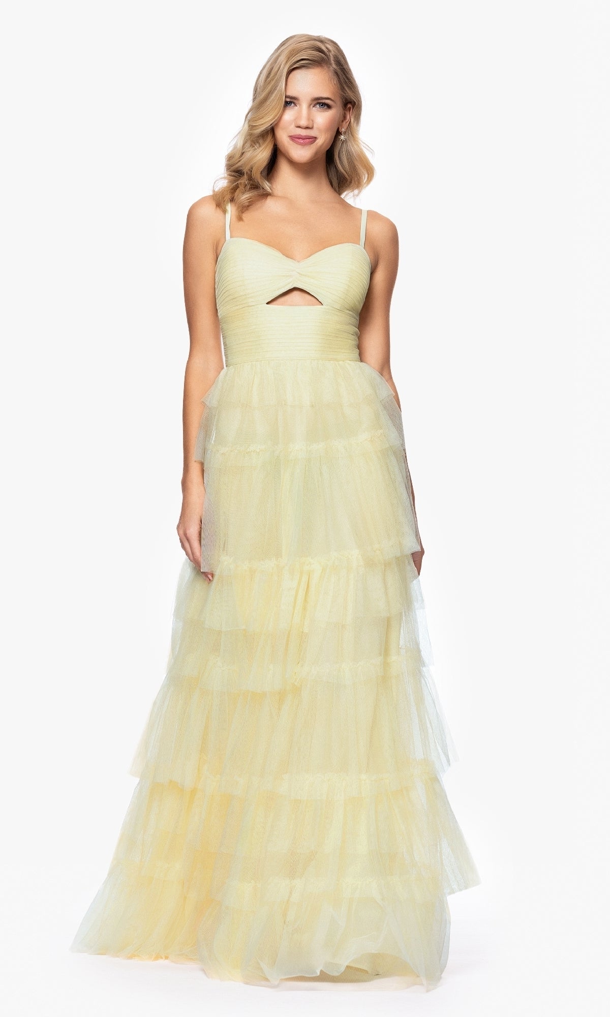 A woman stands against a white background wearing the Blondie Nites 4637BN Long Ruffled Prom Dress—a sleeveless, floor-length pale yellow tulle gown with spaghetti straps, sweetheart bodice, and small front cutout.