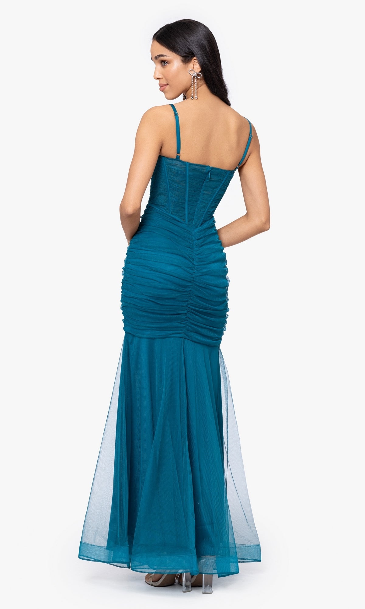A woman models the Corset-Bodice Long Mermaid Prom Dress 4682BN, featuring a teal, ruched, floor-length mermaid silhouette with thin straps and a fitted bodice, shown from the back against a white background.
