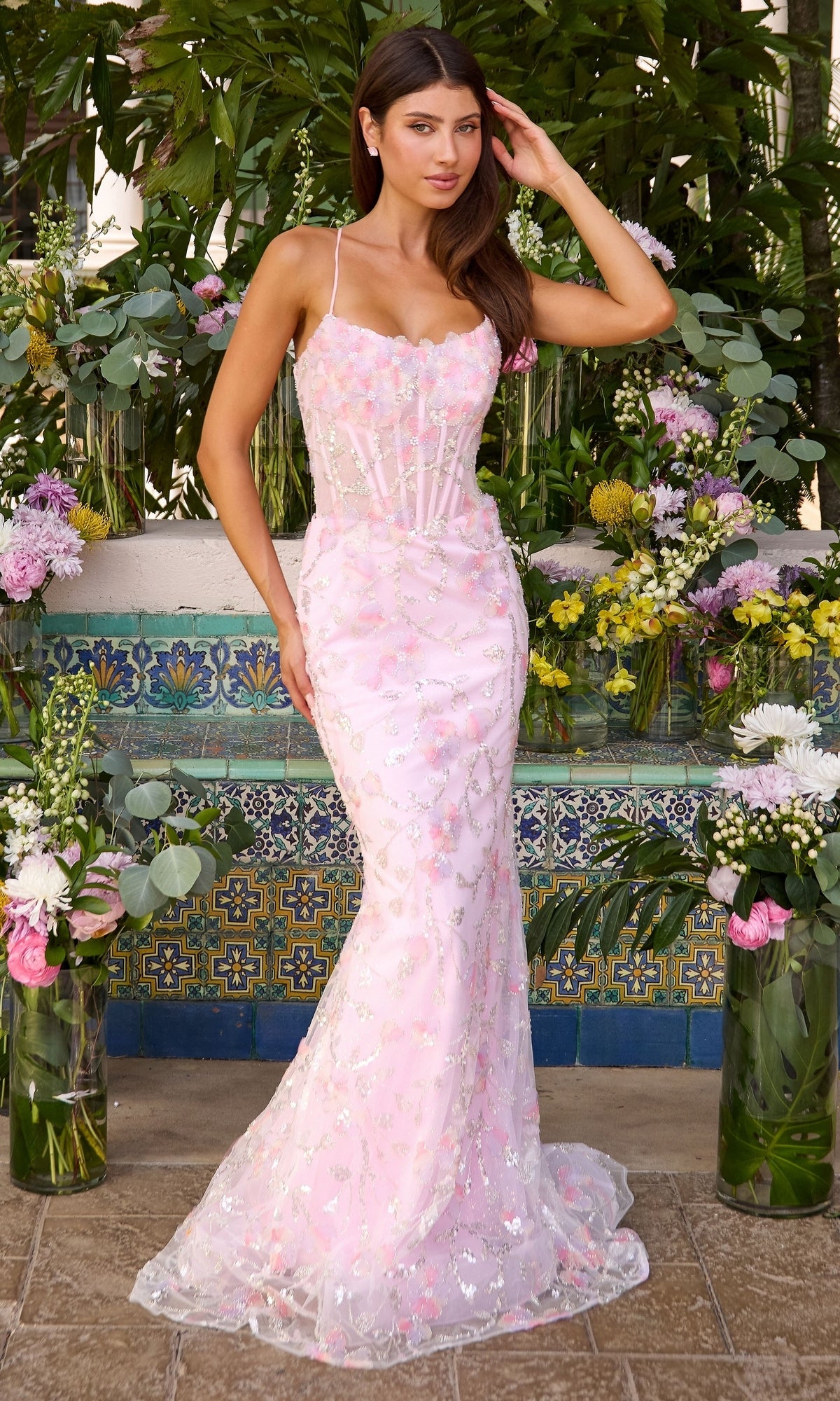 Long Prom Dress: Ava Presley 47411, a floor-length, pastel pink mermaid gown decorated with floral appliques and shimmering embellishments.
