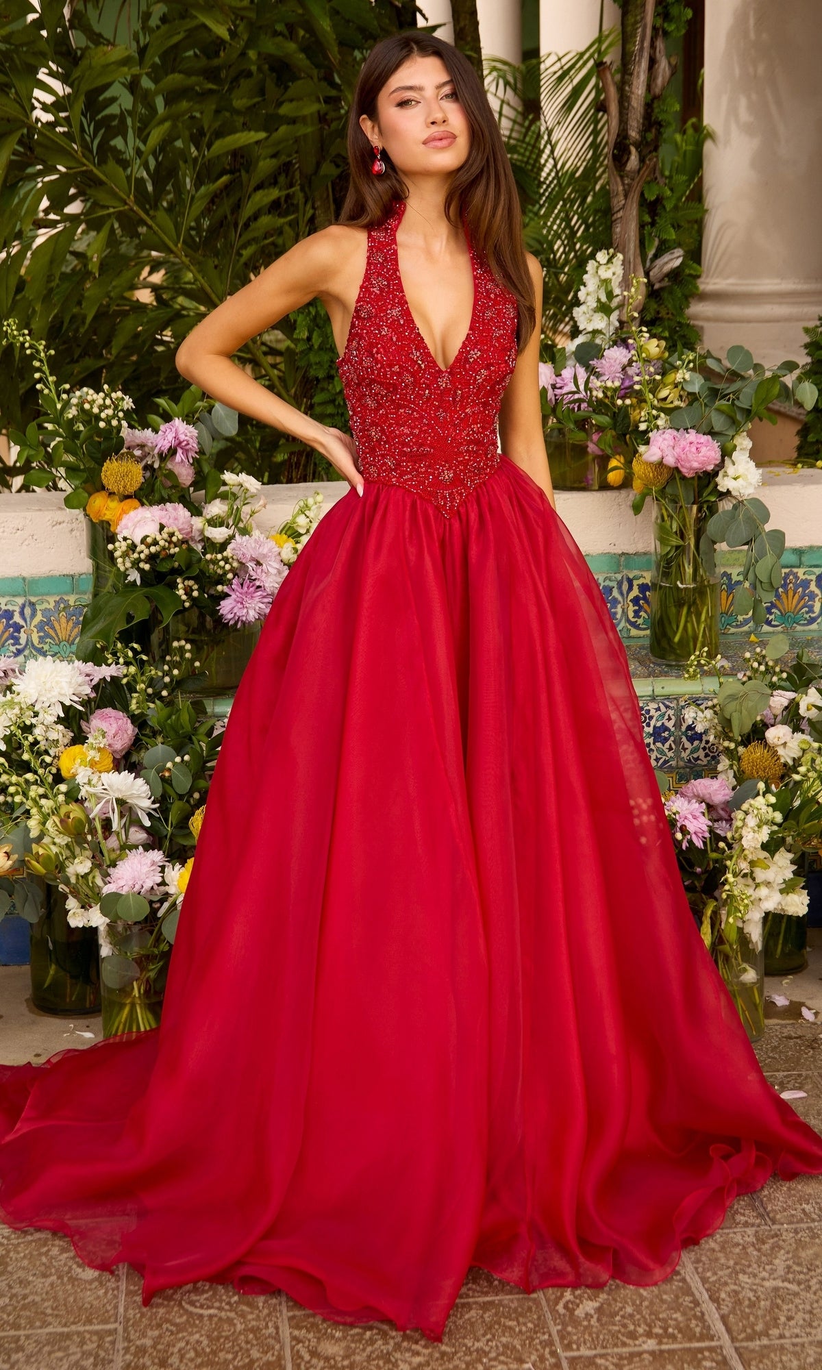 A red floor-length Ava Presley 47425 beaded halter prom dress with a full skirt.