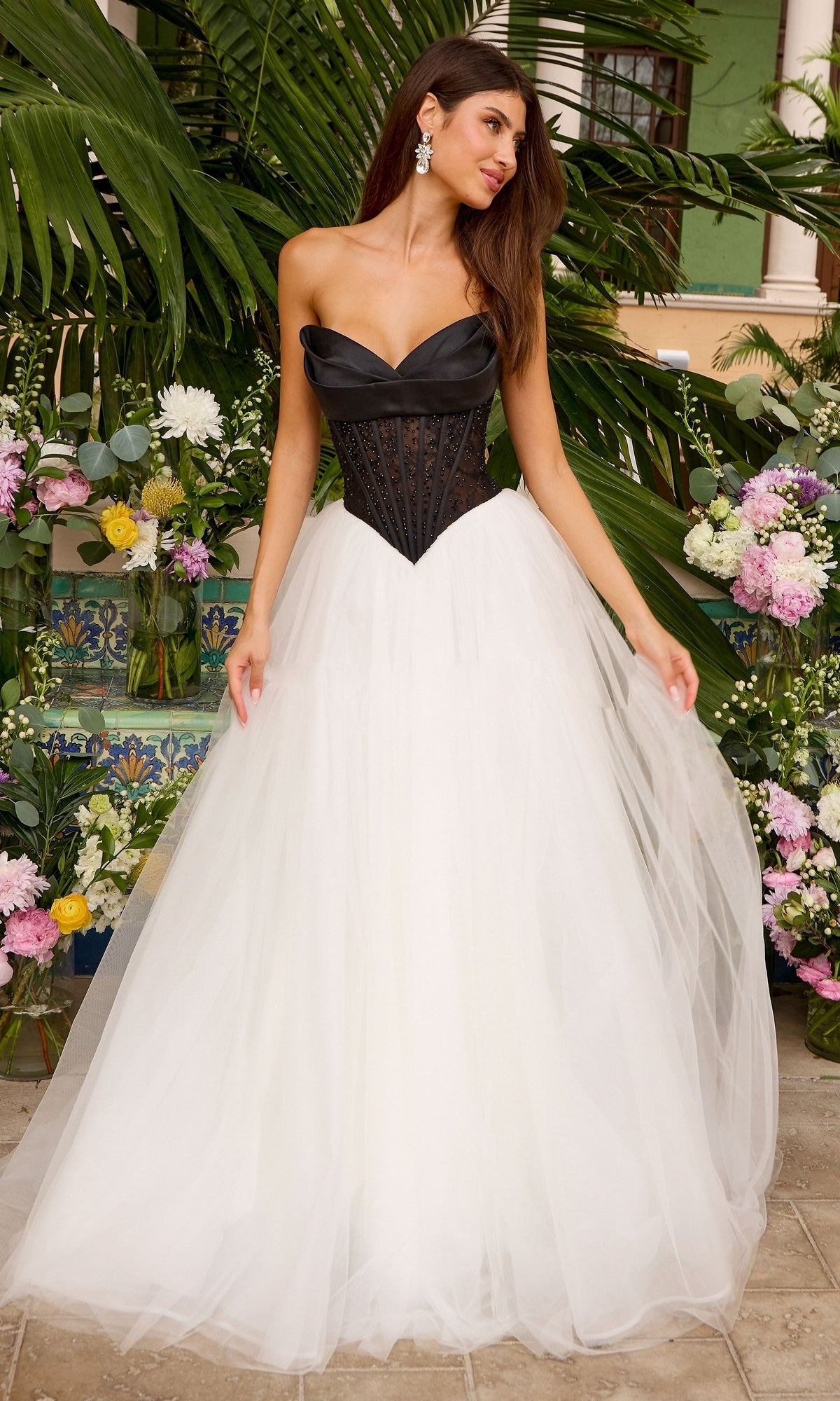 Ava Presley 47484 is a strapless corset ball gown with a black, structured bodice, a sweetheart neckline, and a full-length, white tulle skirt.