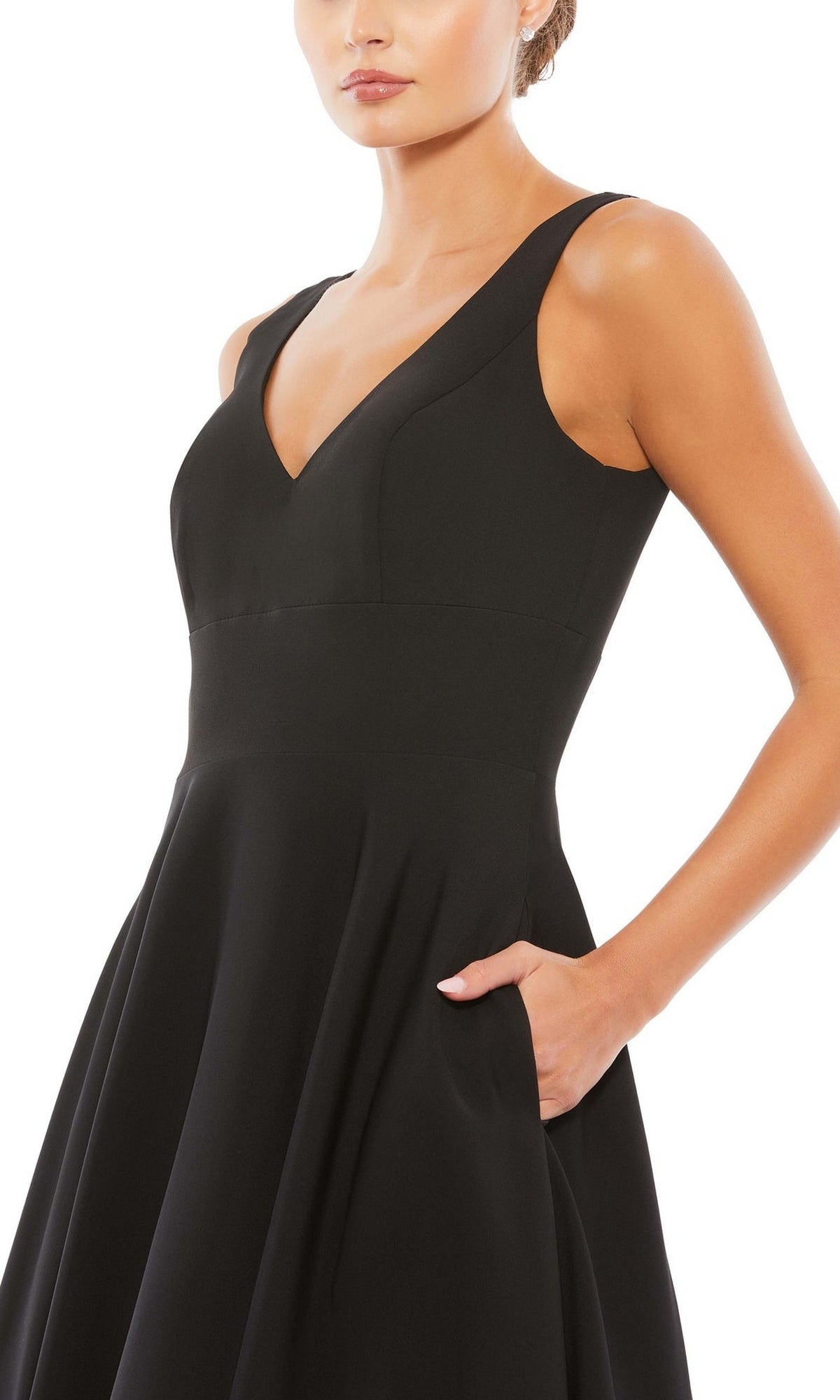 A woman models the Mac Duggal 48924 Classic Long Prom Ball Gown, a sleeveless black dress with a V-neckline and pockets, against a white background.